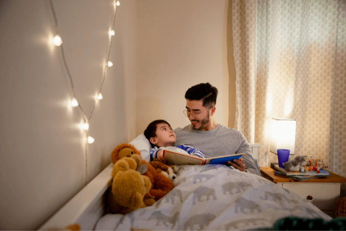 Father reading a book to his son at bedtime.