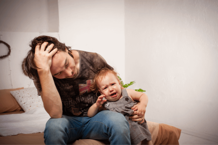 Stressed parent dealing with child's temper tantrums.