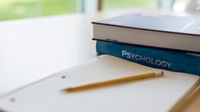 psychology books and notebook atop a desk